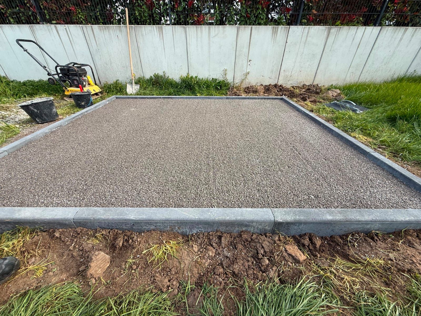Verdichteter Schotter-Unterbau mit gesetzter Randeinfassung, vorbereitet für eine neue Plattenfläche